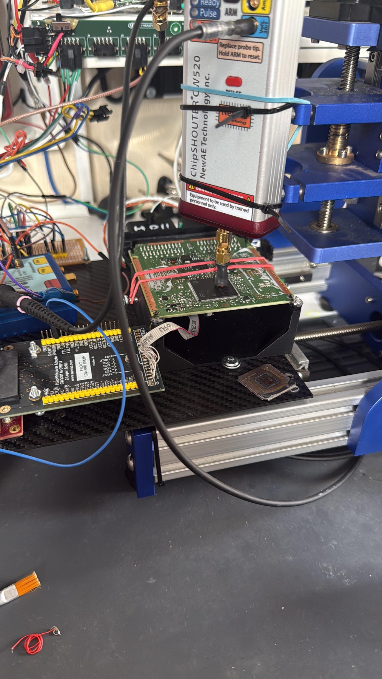 ChipShouter CW520 on the CNC head, tip over the ECU die — NewAE probe, CW308 breakout, decapped target.