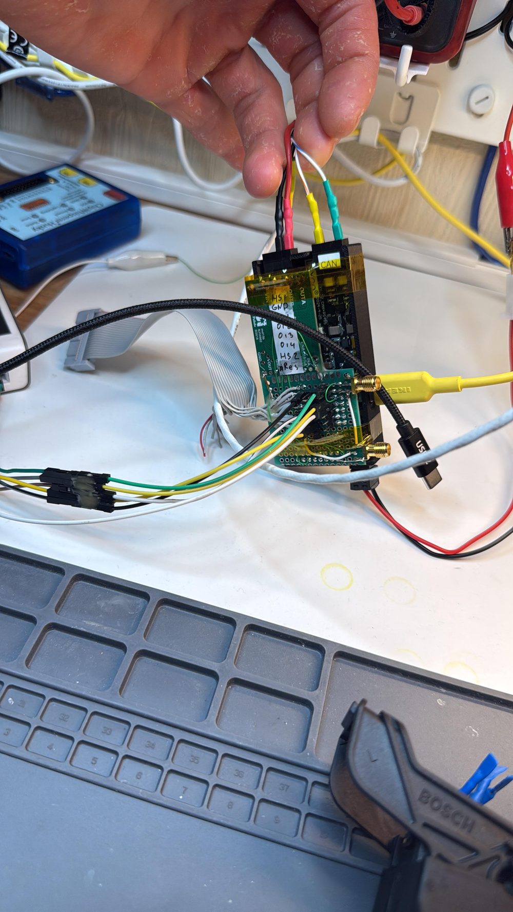 Custom ESP32 board — sequences ECU power, drives nRST, speaks CAN to the BAF. ChipWhisperer-Husky behind.